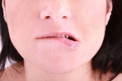 an embarrassed woman biting on her lip Blushing woman